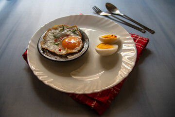 Boiled eggs and egg poach served on a plate. Close up, selective focus.