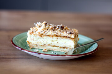 Layered pastry with cream on a plate with a fork.