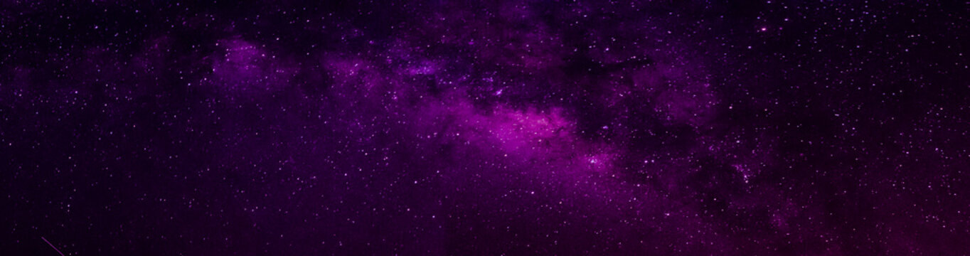 Milky way in night sky and stars on dark background with noise and grain. Long exposure and white balance. Panoramic photo. 