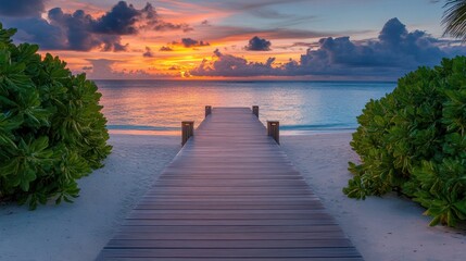 Obraz premium Serene boardwalk at sunset over tropical beach with calm ocean and colorful sky in a tranquil paradise destination