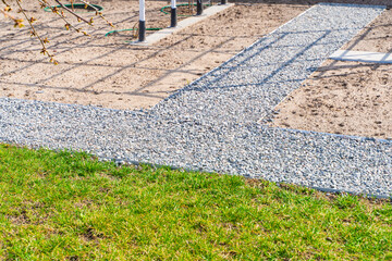 Landscape design on a country plot. Paths covered with gravel, green lawn and soil prepared for...