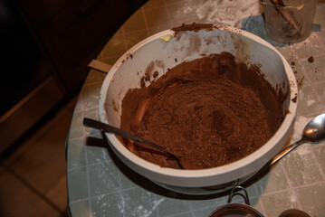 Close-up of chocolate cake batter in a mixing bowl with a spoon, rich texture and cocoa powder