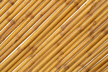 Brown bamboo is arranged diagonally to make a fence, hut or wall of a rural house isolated on white background.