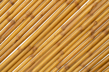 Brown bamboo is arranged diagonally to make a fence, hut or wall of a rural house isolated on white background.