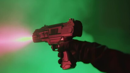 Sci fi gloved hand firing advanced energy weapon, projecting bright pink laser beam against vivid green screen background for visual effects and compositing - Powered by Adobe
