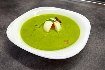 Creamy spring wild garlic soup with bacon and egg