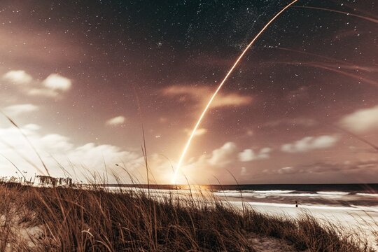 Rocket Trail Illuminates Night Sky Above Coastal Florida Dunes