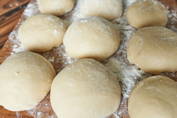 Raw buns on a cutting board with flour. Selective focus.