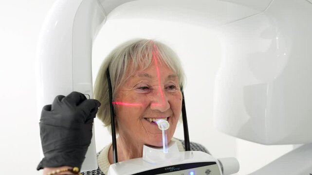 Senior woman receiving advanced 3d dental scan using white modern scanner with red laser lights, showcasing cutting edge dental diagnostic technology