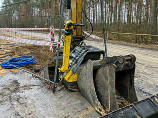 Fenced excavations in the ground along the road during construction of the sewage system
