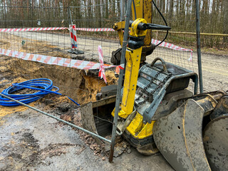 Fenced excavations in the ground along the road during construction of the sewage system