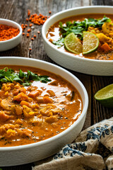 Red lentil sweet potato and coconut soup on wooden table