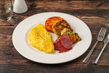 Rustic breakfast plate with fried eggs, grilled vegetables, and turkey bacon