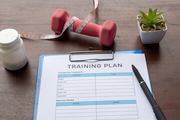 Gym Training Form and Dumbbell on Wooden Surface