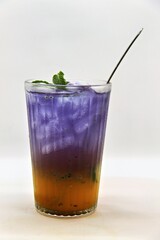 Refreshing Indonesian drink made with passion fruit and butterfly pea flower, Es Markisa Bunga Telang. Naturally vibrant with a sweet and tangy flavor, served cold with ice.