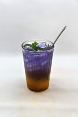 Refreshing Indonesian drink made with passion fruit and butterfly pea flower, Es Markisa Bunga Telang. Naturally vibrant with a sweet and tangy flavor, served cold with ice.