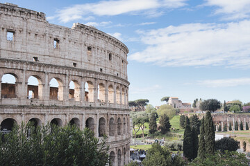 The colosseum in rome, italy, is a breathtaking sight, showing off its ancient architecture under a sky dotted with clouds, evoking a sense of history and wonder