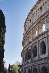 Colosseum in rome, italy, rises majestically against a vibrant blue sky, with ancient arches and weathered stone reflecting its rich history and architectural grandeur