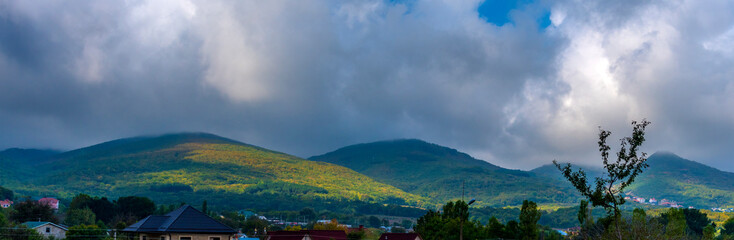 picturesque Crimean mountains covered with dense forest. Summer landscape turns into autumn, with...