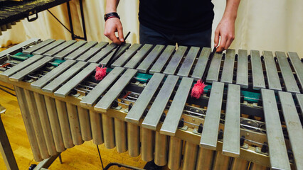 A young guy playing the vibraphone at a music school.
