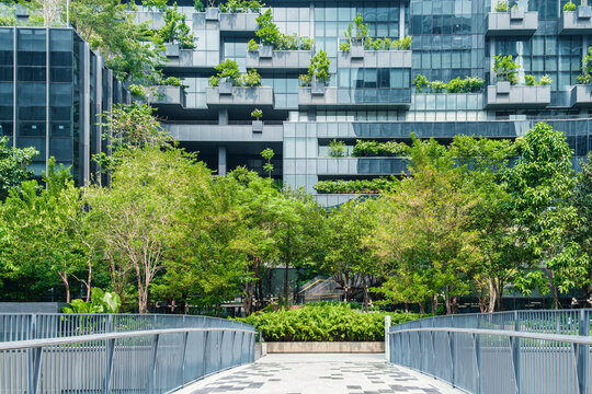 Modern eco-friendly architecture with vertical garden and greenery surrounding office glass building in urban environment in Bangkok city, Thailand. Green architecture and sustainable design