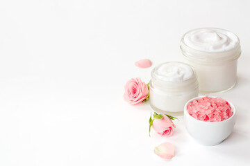 Closeup of pink roses essence skin care cream with flowers and petals