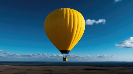 Obraz premium Vivid yellow hot air balloon soars high above a landscape