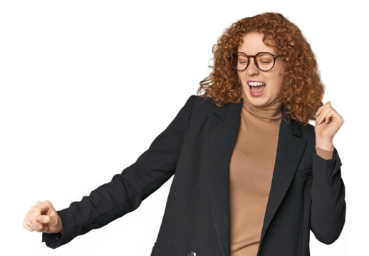 Young Caucasian redhead in business attire dancing and having fun.