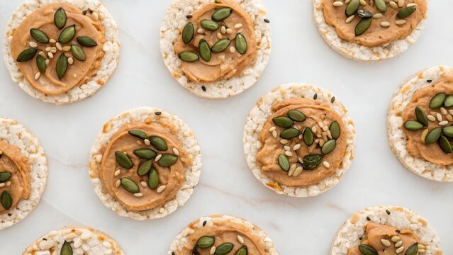 A visually appealing arrangement of rice cakes topped with nut butter and seeds, showcasing a healthy snack option.