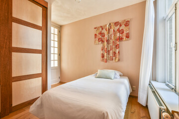 A serene bedroom featuring minimalistic decor, soft colors, and a unique wall hanging creating a calm atmosphere perfect for relaxation.