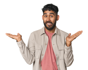 Young Hispanic man isolated confused and doubtful shrugging shoulders to hold a copy space.