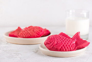 Sweet bread in the shape of a crucian carp fish with banana milk on a light table. Poonoppan dessert. Korean food.