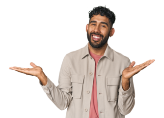 Young Hispanic man isolated makes scale with arms, feels happy and confident.