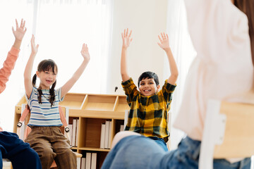 Excited primary school kids from various backgrounds express happiness together. Cheerful classroom scene captures essence of modern education, highlighting unity and active participation