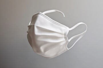Clean White Fabric Surgical Mask with Elastic Straps on Grey Background Studio Shot