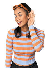 Young Filipino woman in studio trying to listening a gossip.