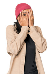 Young Filipino woman in studio blink through fingers frightened and nervous.