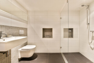 A sleek and contemporary bathroom showcasing stylish tiles, a modern sink, and a minimalist design that enhances the overall aesthetic appeal.