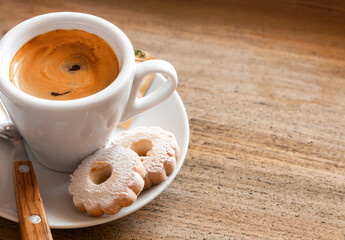Italian breakfast with espresso coffee and canestrelli biscuits on wooden table