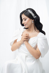 A graceful bride with a soft bride with a soft smile and delicate hands. Her elegant white dress...