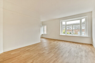 An airy and well-lit empty room with clean walls and wooden flooring. The large window brings in natural light, perfect for various interior design possibilities.