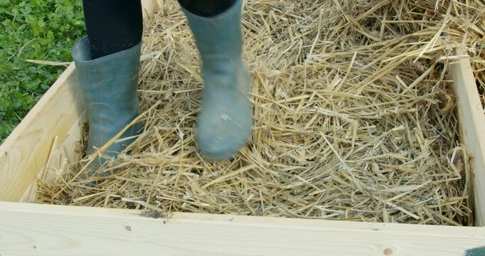 Young Woman Building a Raised Garden Bed in Backyard