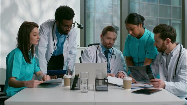 Teamwork group multiethnic team diverse doctors collaboration medical people brainstorming using laptop discuss illness medicine talking patient treatment analyzing health test results clinic cabinet