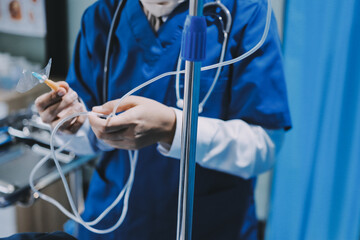 A nurse with IV drip and patient in bed in hospital room.