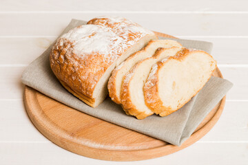Assortment of freshly sliced baked bread with napkin on rustic table top view. Healthy unleavened bread. French bread slice