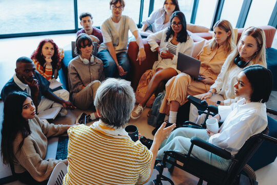 Diverse college group in engaging discussion with instructor, fostering inclusion and learning in a collaborative setting