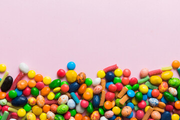 Mixed collection of colorful candy, on colored background. Flat lay, top view. frame of colorful chocolate coated candy