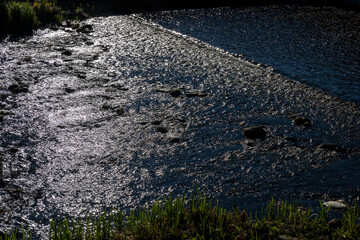 river with a large current , part of a river with a large rapid flow of water in sunny weather, top view