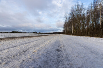 ground and melted snow on an asphalt road in winter, landscape photography