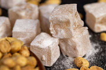 Turkish delight cubes and toasted peanuts on a slate , side view